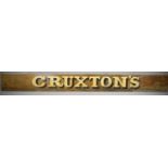 A Painted Wooden Shop Sign, "Cruxton's", 239cm long