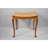 A Walnut Framed Cane Seated Dressing Table Stool on Cabriole Supports, 49cm wide
