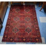 A Hand Knotted Afghan Kunduz Patterned Woollen Rug on Red Ground, 187 x 122cm