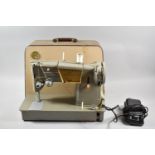 A Vintage Cased Electric Singer Sewing Machine with Foot Pedal