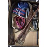 A Box Containing Various Horse Girths, Stirrups and Two Riding Whips