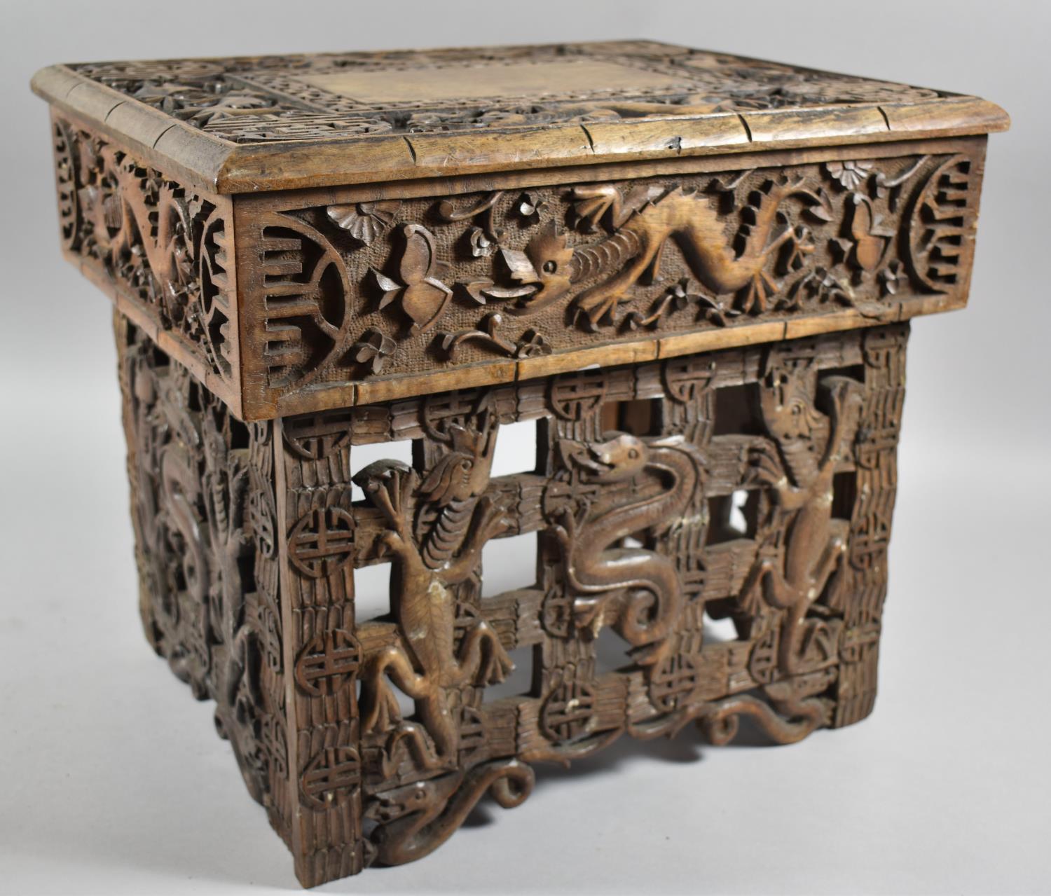 An Interesting Heavily Carved Oriental Folding Box Seat Decorated with Dragons, One Panel Missing