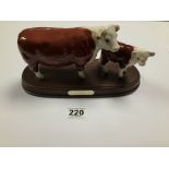 A BESWICK HEREFORD COW AND CALF ON A WOODEN PLINTH