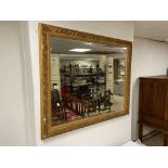 AN ORNATE GILDED BEVELLED EDGED MIRROR 115 X 96 CMS