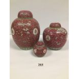 A GRADUATED SET OF THREE PINK AND YELLOW CHINESE LIDDED GINGER JARS, LARGEST 28CM HIGH