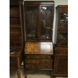 A WALNUT EDWARDIAN SECRETAIRE ON BALL AND CLAW FEET