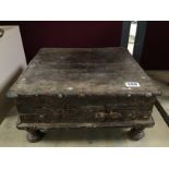 A EARLY 19TH CENTURY SMALL WOODEN UNIT RAISED UPON TURNED FEET WITH CARVED AREAS AND METAL STUDS