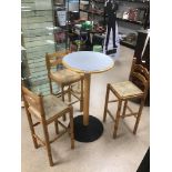 A BISTRO TABLE WITH THREE BAR STOOLS