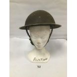 A 20TH CENTURY MILITARY HELMET WITH ORIGINAL MESH STRAP, 30.5CM WIDE