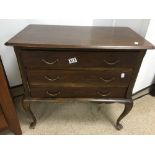 A SMALL THREE DRAWER CHEST OF DRAWERS ON CABRIO LEGS