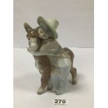 A LLADRO PORCELAIN FIGURE GROUP OF A GIRL HUGGING A DONKEY, 19CM HIGH (AF)