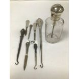 AN UNUSUAL SILVER TOPPED GLASS PERFUME BOTTLE, 14CM HIGH, TOGETHER WITH SEVEN SILVER HANDLED ITEMS