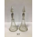 A PAIR OF SILVER MOUNTED CUT GLASS SCENT BOTTLES WITH STEEPLE STOPPERS. 23.5CM HIGH