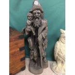 A WOODEN CARVED GENTLEMAN WITH A CHILD BOTH WITH GLASS EYES 103CMS HIGH