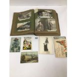 AN EARLY 20TH CENTURY POST CARD ALBUM CONTAINING UNUSUAL CARDS FROM AROUND THE WORLD, SOME BEING