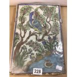 AN EARLY PERSIAN CERAMIC TILE SHOWING AN EXOTIC BIRD PERCHING ON A TREE BY A WATERWAY, 36.5CM BY
