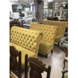 A MUSTARD YELLOW VELVET BUTTON BACK THREE SEAT SOFA, RAISED UPON WOODEN SUPPORTS, 120CM WIDE BY