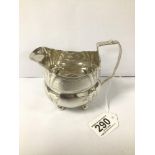 A GEORGE III SILVER MILK JUG OF OVAL FORM WITH FLORAL ENGRAVED DECORATION THROUGHOUT, RAISED UPON