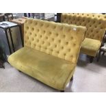 A MUSTARD YELLOW VELVET BUTTON BACK THREE SEAT SOFA, RAISED UPON WOODEN SUPPORTS, 120CM WIDE BY