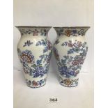 A PAIR OF LATE 19TH CENTURY CERAMIC VASES DECORATED WITH FLORAL MOTIFS, 24.5CM HIGH (AF)