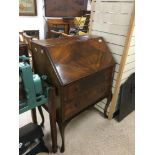 A MAHOGANY BUREAU/DESK ON CABRIOLET LEGS