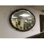 A VINTAGE BEVELLED EDGED MIRROR WITH CARVED LEAVES TO THE FRONT 78 X 53 CM