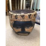 A VINTAGE TRIBAL DRUM FEATURING CARVING OF A FACE BLACKENED EYES TO THE FRONT AND BACK, 43 X 38CMS