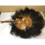AN AFRICAN TRIBAL HAND FAN, LEATHER HANDLE SURROUNDED BY FEATHERS