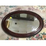 A VINTAGE MAHOGANY OVAL MIRROR