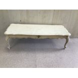 A CREAM WOODEN COFFEE TABLE WITH A WHITE MARBLE TOP
