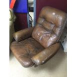 A VINTAGE BROWN LEATHER SWIVEL ARM CHAIR
