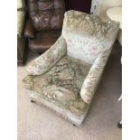 A 1920'S, 1930'S ARMCHAIR ON CASTORS