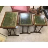 A NEST OF THREE GREEN LEATHER TOP TABLES