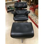 A BLACK LEATHER EAMES STYLE RETRO CHAIR WITH STOOL