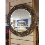 A ROUND VINTAGE BEVEL EDGE MIRROR WITH A DECORATIVE SURROUND BY AISONIA 63CMS DIAMETER