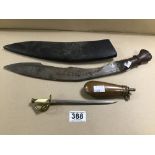 AN INDIAN KUKRI KNIFE IN ORIGINAL LEATHER SHEATH, TOGETHER WITH A BRASS POWDER FLASK AND A NOVELTY