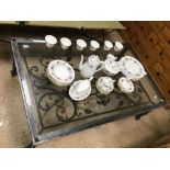 A LARGE IRON WORKED COFFEE TABLE WITH A DECORATIVE FEATURE AND GLASS TOPPED