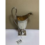 A SILVER HELMET SHAPED CREAM JUG WITH ENGRAVED DETAILING THROUGHOUT AND A GILT INTERIOR,