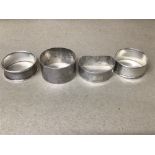 A GROUP OF FOUR SILVER NAPKIN RINGS, ALL WITH ENGINE TURNED DECORATION, THE EARLIEST HALLMARKED