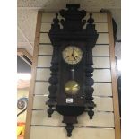 A BLACK FOREST STYLE WALL CLOCK WITH KEY AND PENDULUM