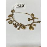 A 9CT GOLD CURB LINK CHARM BRACELET WITH TWO HEART PADLOCKS AND ELEVEN HANGING CHARMS, SOME MARKED
