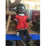 A 20TH CENTURY BLACK PEDIGREE DOLL, WEARING A RED DRESS