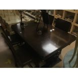 A DARK OAK EXTENDING DINING TABLE WITH ORNATE BASE AND FOUR LEATHER STUDDED CHAIRS FULLY EXTENDED