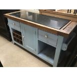 A SOLID WOODEN KITCHEN ISLAND WITH A BLACK MARBLE TOP AND DRAWERS AND A CUPBOARD SPACE IN LIGHT BLUE