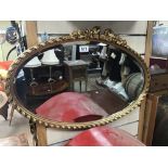 A VINTAGE GILDED FRAMED OVAL MIRROR BEVELLED EDGE 71 X 48CMS