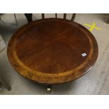 AN INLAID CIRCULAR WOODEN TABLE WITH BRASS ENDS TO FEET