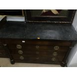 A FRENCH EMPIRE STYLE FOUR DRAWER CHEST WITH A BLACK MARBLE TOP AND DECORATED BRASS HANDLES