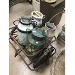 A VINTAGE FRENCH MILK TROLLEY WITH FOUR MILK CHURNS