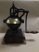 A LARGE CAST IRON PEUGEOT FRERES 'A3' COFFEE GRINDER WITH BRASS COVERS, MOUNTED UPON A WOODEN