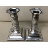 A PAIR OF VICTORIAN SILVER REEDED COLUMN-AID CANDLESTICKS ON SQUARE BASES, HALLMARKED LONDON 1883 BY